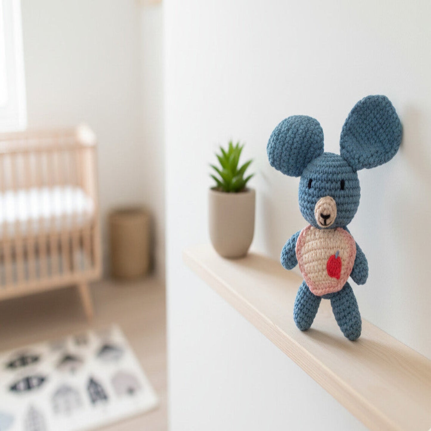 Handmade blue koala amigurumi standing on a wooden shelf in a Nordic-style nursery; a minimalist and artisanal decorative piece made in Italy by Cepaale