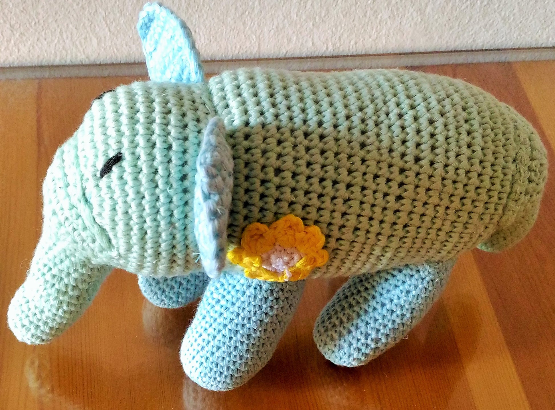 Crochet elephant amigurumi with yellow flower accent - Handcrafted plush decor
