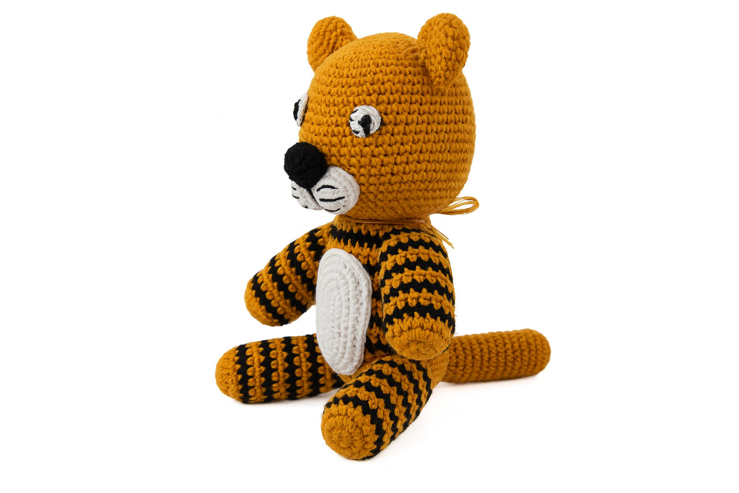Side view of handcrafted amigurumi tiger toy showing striped body and sitting position on white background