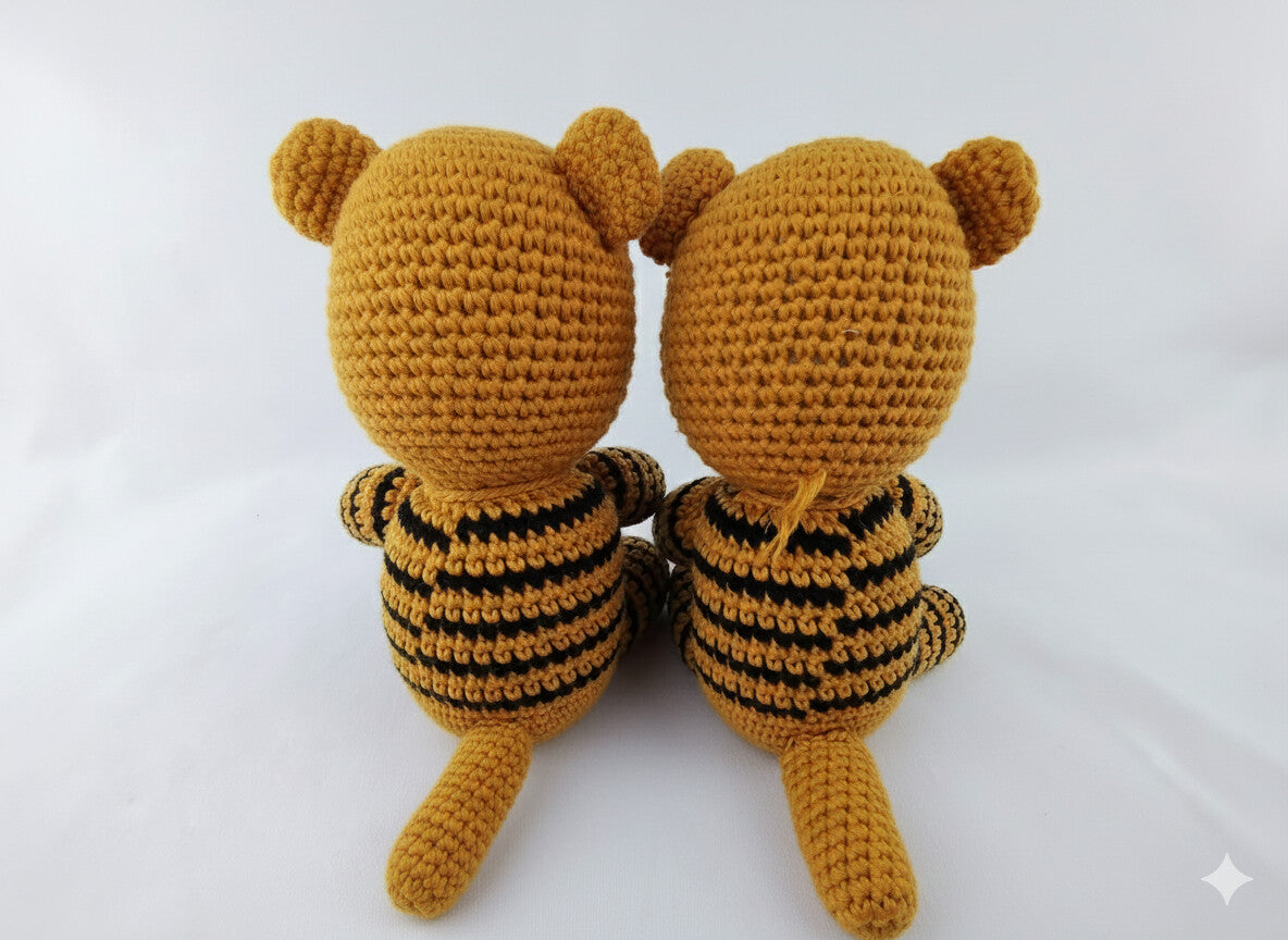 Back view of two crocheted tiger toys showing detailed stripe work and rounded ears