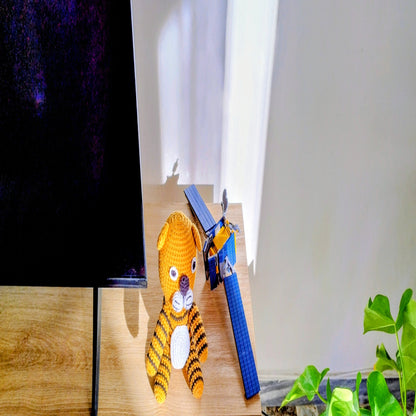 Handcrafted crochet tiger toy displayed on modern sofa with houseplants, artisan nursery decor gift for contemporary homes