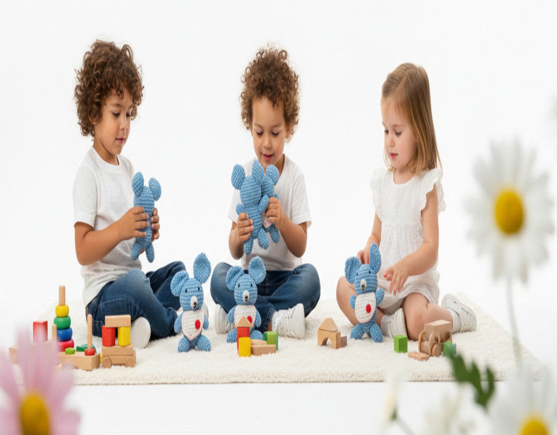 children playing with blue handmade koala amigurumi in a cozy nursery; happily holding the soft crochet toys 
