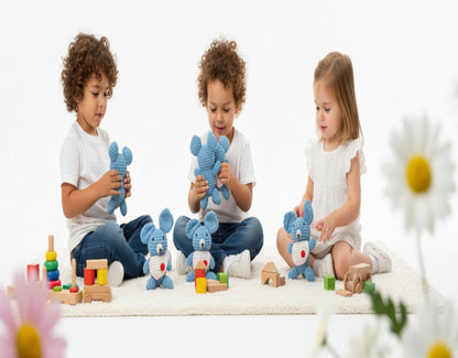 children playing with blue handmade koala amigurumi in a cozy nursery; happily holding the soft crochet toys 