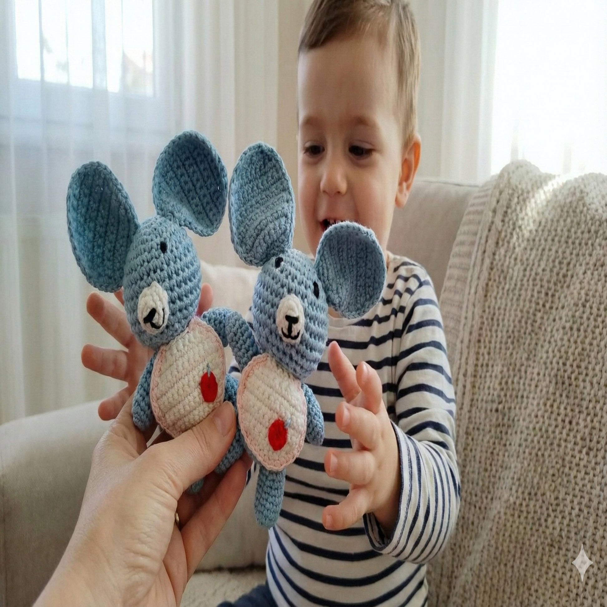 A mother gifting two handmade koala amigurumi to her young son, showcasing soft artisanal toys made in Italy by Cepaale