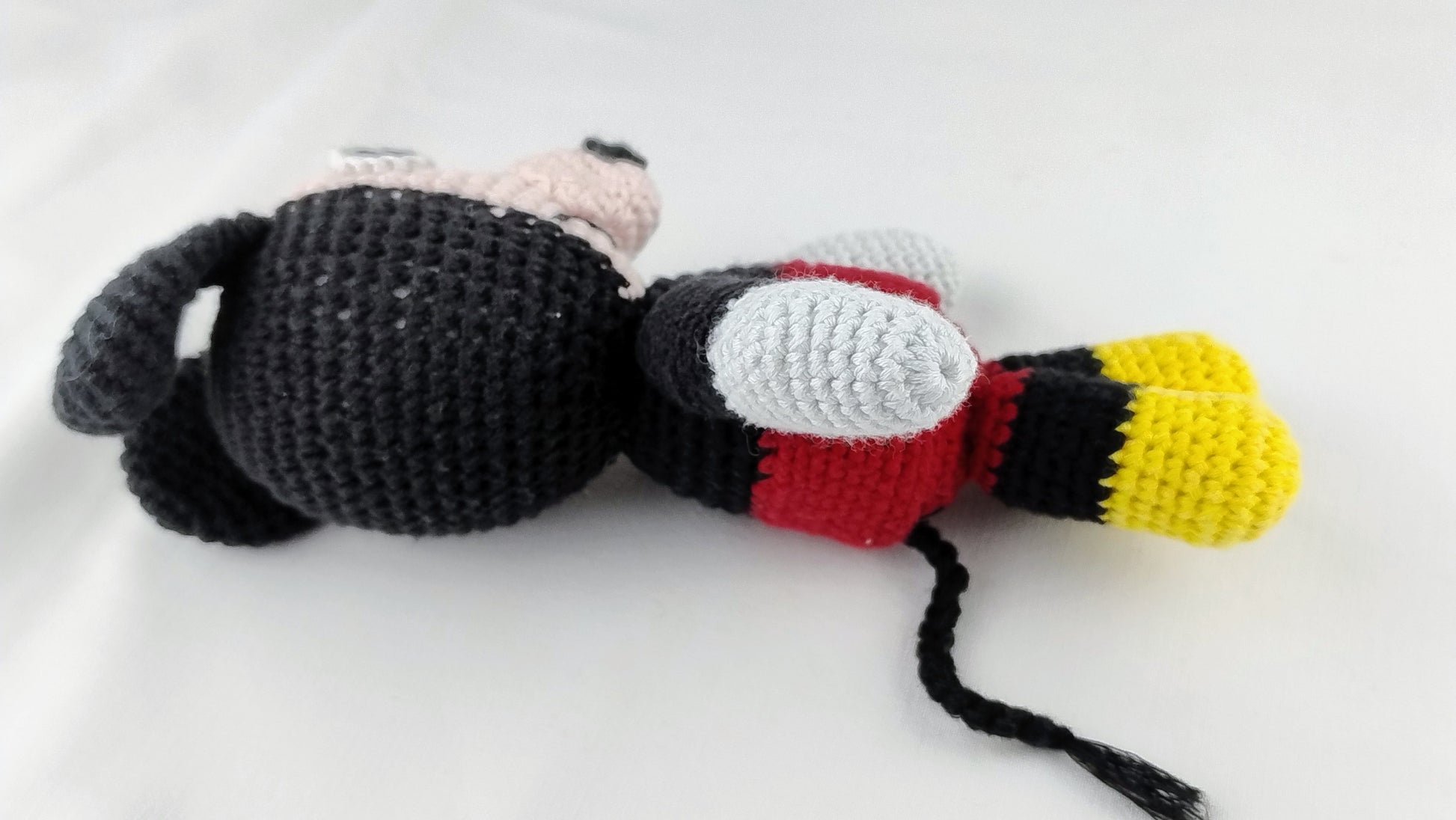 Side profile of a handmade mouse amigurumi showing the artisanal crochet stitch texture and 3D details; a high-quality nursery plush toy  by Cepaale