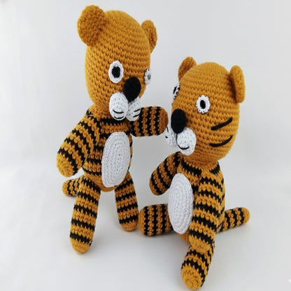 Handmade nursery decor crochet tiger stuffed animal in mustard white with black stripes displayed friendly on a white background